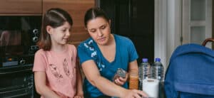 A woman and child preparing food, water and provisions for home storage