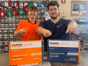Two Cairns Hardware workers smiling and gesturing to products
