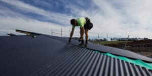 A man installing roofing