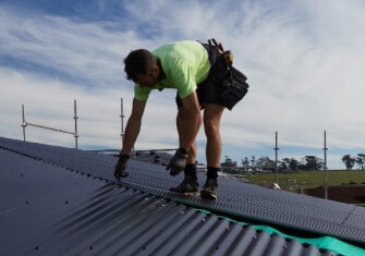 A man installing roofing